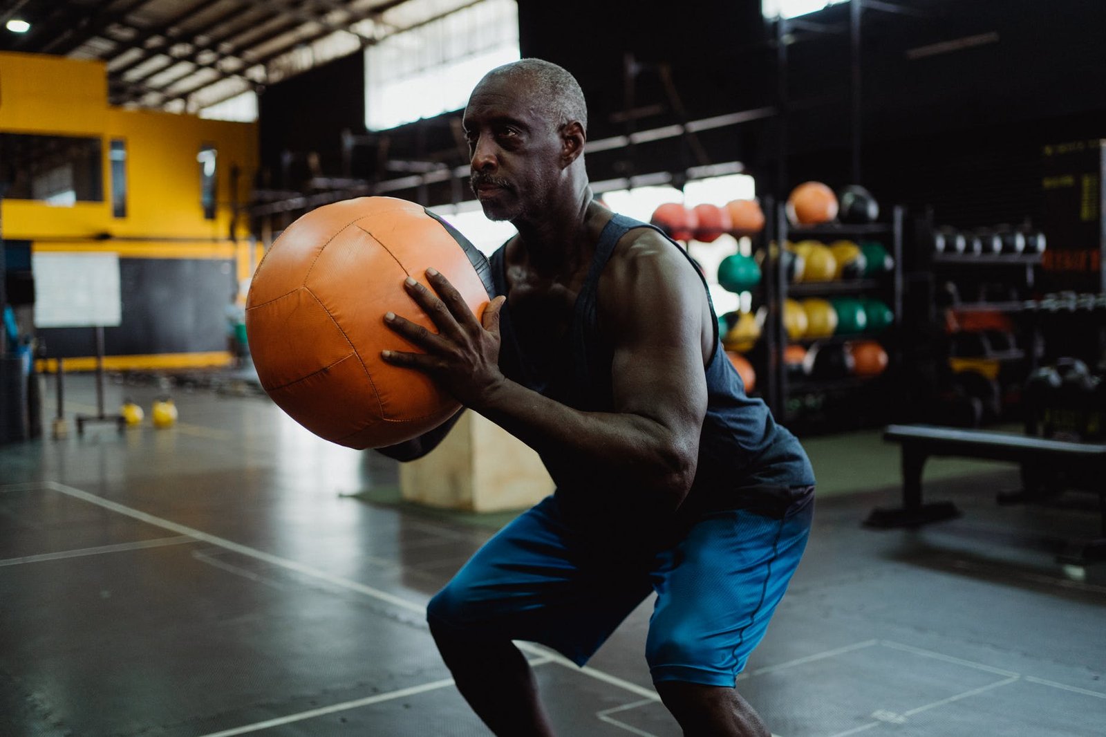man holding orange ball in squat position